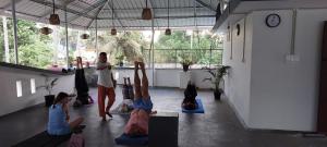 a group of girls doing yoga in a room at White House Residency in Varkala