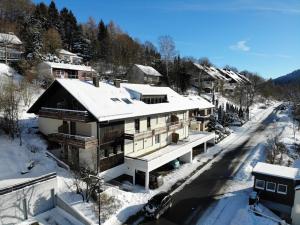 a house is covered in snow with a road at Ferienwohnung Südhang in Winterberg