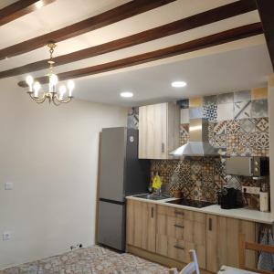 una cocina con nevera de acero inoxidable y armarios de madera en Casa Pp en Finestrat