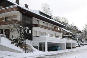 ein Apartmenthaus mit einem Auto im Schnee in der Unterkunft Ferienwohnung Südhang in Winterberg