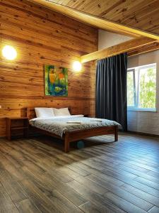 um quarto com uma cama num chalé de madeira em Садиба Бабина Лоза em Lisove