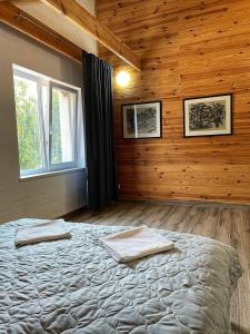 ein Schlafzimmer mit einem großen Bett in einem Zimmer mit Holzwänden in der Unterkunft Садиба Бабина Лоза in Lisove