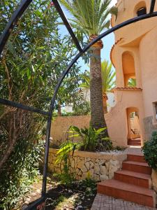 a house with a palm tree and stairs in front at Casa Veintiuno en Calp in Calpe