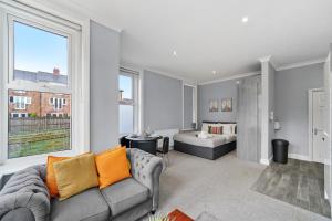 ein Wohnzimmer mit einem Sofa und einem Bett in der Unterkunft Glamorous Studio for 2 people - Maidstone Town Centre - f2 BridgeCity in Kent