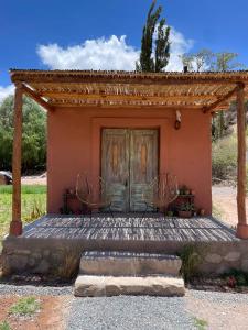 a house with two chairs sitting on a porch at KUSY WAYRA in Maimará