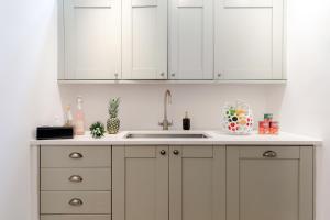 a kitchen with white cabinets and a sink at RARE FIND off Oxford St! SOHO 5bed Design House For XXL Groups in London