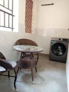 mesa y sillas en una habitación con lavadora en Luxurious Homes AthiRiver, en Athi River