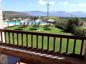 a balcony with a view of a pool with umbrellas at Simosmare Resort in Elafonisos
