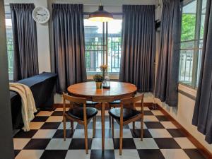 une salle à manger avec une table, des chaises et une horloge dans l'établissement Entire 2-storey house, 2 br, 2 toilet and shower, 2 car parks, only 400 m from MRT Huai Kwang, à Ban Na Song