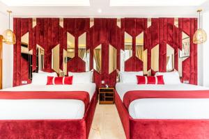 2 camas en una habitación con cortinas rojas en One Hotel Casablanca, en Casablanca