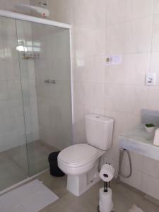 a white bathroom with a toilet and a shower at Fazenda do Bosque - Pousada e Capril in Paraty
