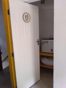 a door leading into a kitchen with a clock on the wall at Fazenda do Bosque - Pousada e Capril in Paraty