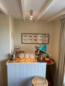 a counter with glasses and a hat on it at Luxury homely open-plan Barn with log burner & games room in Wrexham