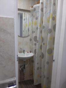 a bathroom with a sink and a shower curtain at Mundo Turismo Hostel in Medellín