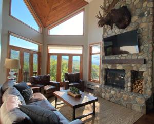 sala de estar con sofá y chimenea en C12 Homey Bretton Woods slopeside townhome for your family getaway to the White Mountains, en Carroll
