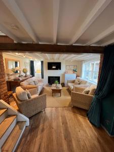 a living room with couches and a fireplace at Luxury homely open-plan Barn with log burner & games room in Wrexham