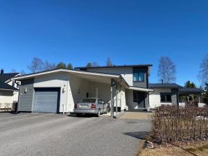 une maison avec une voiture garée dans une allée dans l'établissement Pajupilli 1-10 henkilölle, à Kajaani