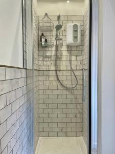 a shower in a bathroom with a glass door at The Cowshed - Cottage in Cornwall in Jacobstow