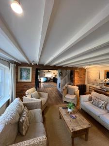 uma grande sala de estar com sofás e uma mesa em Luxury homely open-plan Barn with log burner & games room em Wrexham
