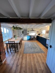 a kitchen and living room with a table and a dining room at Luxury homely open-plan Barn with log burner & games room in Wrexham