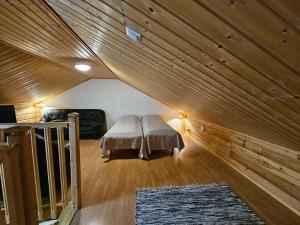 1 dormitorio con 1 cama en una habitación con techos de madera en Tahko Villa Vaarna, en Tahkovuori