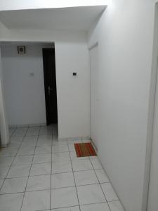 a hallway with white walls and a black door at Boys accommodation in Sharjah