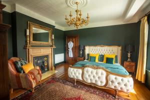 a bedroom with a bed and a fireplace and a chandelier at House of Brohedyn in Newcastle Emlyn