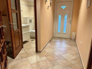 einen Flur mit Tür und Fliesenboden in der Unterkunft Chic Deluxe Villa in Iaşi