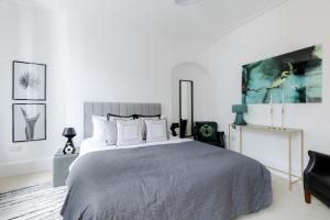a bedroom with a large bed and a black chair at RARE FIND off Oxford St! SOHO 5bed Design House For XXL Groups in London