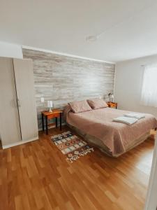 a bedroom with a bed and a wooden floor at Departamento Kran in Punta Arenas