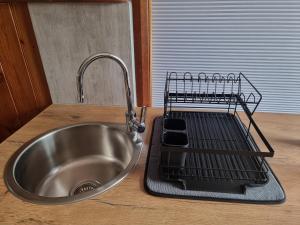 a metal sink in a kitchen with a dish drying rack at Lyell Cottage Queenstown Comfortable and Warm in Queenstown +42 photos