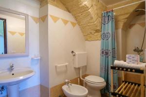 y baño con lavabo, aseo y espejo. en masseria Furca, en Serra Alimini
