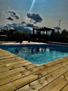 a swimming pool with a wooden deck and a gazebo at Koselig rom i tømmerhus, inkl morgenkaffe in Eidsvoll