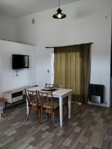 een eetkamer met een tafel, stoelen en een televisie bij Inhala y exhala in Mar del Plata
