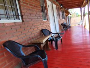 a row of benches sitting on a porch at Don Alejandro Apart Iguazu in Puerto Iguazú