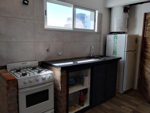 een keuken met een fornuis, een wastafel en een koelkast bij Inhala y exhala in Mar del Plata +5 foto's