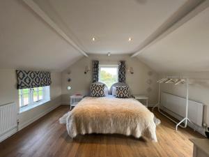 Un dormitorio con una cama grande y una ventana en Luxury homely open-plan Barn with log burner & games room, en Wrexham