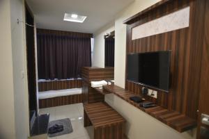 a bathroom with a television and wooden walls at Hotel Royal Residency in Vadodara