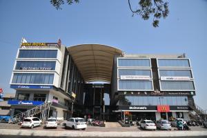 a building with cars parked in a parking lot at Hotel Royal Residency in Vadodara