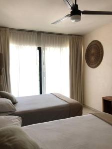 um quarto com 2 camas e uma ventoinha de tecto em Unique Design Apartment in La Veleta em Tulum