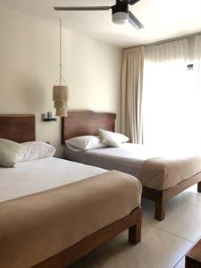 um quarto com 2 camas e uma janela em Unique Design Apartment in La Veleta em Tulum
