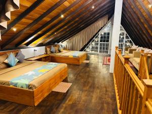 1 dormitorio con 2 camas en una habitación con techos de madera en Cabin 7000 feet Nuwaraeliya, en Nuwara Eliya