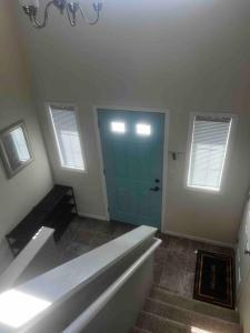 Habitación con puerta azul y escalera en Charming Retreat with Modern Comforts en West Fargo