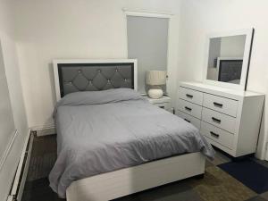 1 dormitorio con cama, tocador y espejo en NYC Gateway: Cozy Home with Easy Access, en Passaic