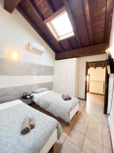 a bedroom with two beds and a skylight at Piccinardi house - appartamento 4 posti letto in Crema