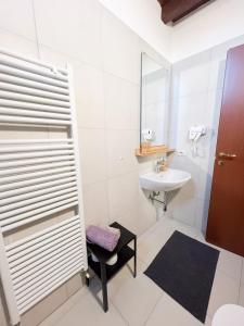 Piccinardi house - appartamento 4 posti letto في كريما: حمام أبيض مع حوض ومرآة