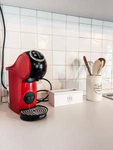 Piccinardi house - appartamento 4 posti letto في كريما: آلة صنع القهوة الحمراء والسوداء موجودة على منضدة