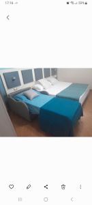 サーラ・コンシリーナにあるAffittacamere Certe Nottiの青いベッド2台が備わるドミトリールームのベッド1台分です。