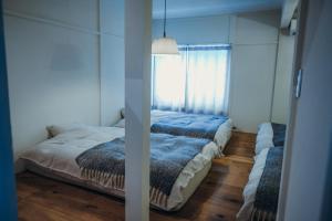 石打丸山スキー場徒歩30秒一棟まるまる貸切フルリノベーションのお宿 في Seki: غرفة نوم بسرير ونافذة