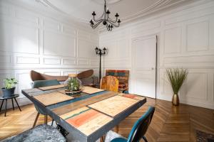 a dining room with a wooden table and chairs at Au marche aux puces de saint ouen in Saint-Ouen